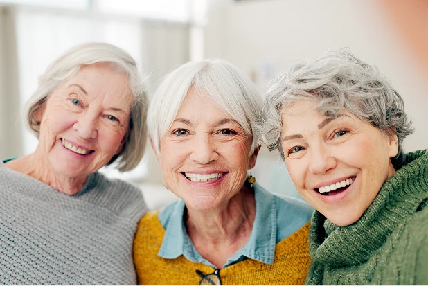 Elderly woman smiling while speaking with a home care specialist during a visit