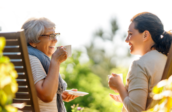 woman and caretaker drinking tea on porch