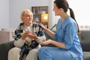 Elderly woman with caregiver discussing medication, highlighting need for full-time care support