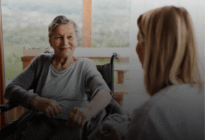 client-2 Senior woman smiling at caregiver during a warm in-home visit, companionship and support
